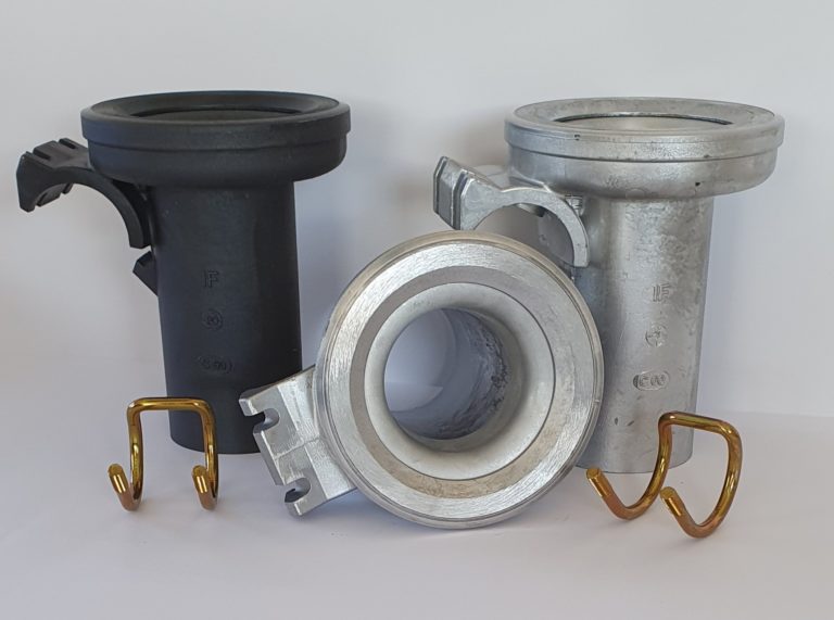 Der Installateur zeigt drei Metallrohrverbinder, zwei goldfarbene Haken und Ersatzteile vor einem weißen Hintergrund.
